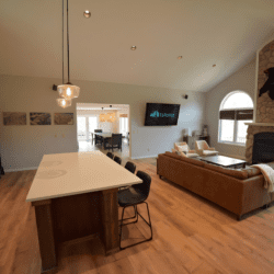 Contemporary kitchen island and cozy living area with fireplace and large windows in an open-concept vacation rental.