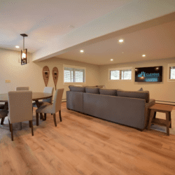 Open-concept living and dining area with modern seating, wood floors, and warm lighting in a spacious vacation rental.