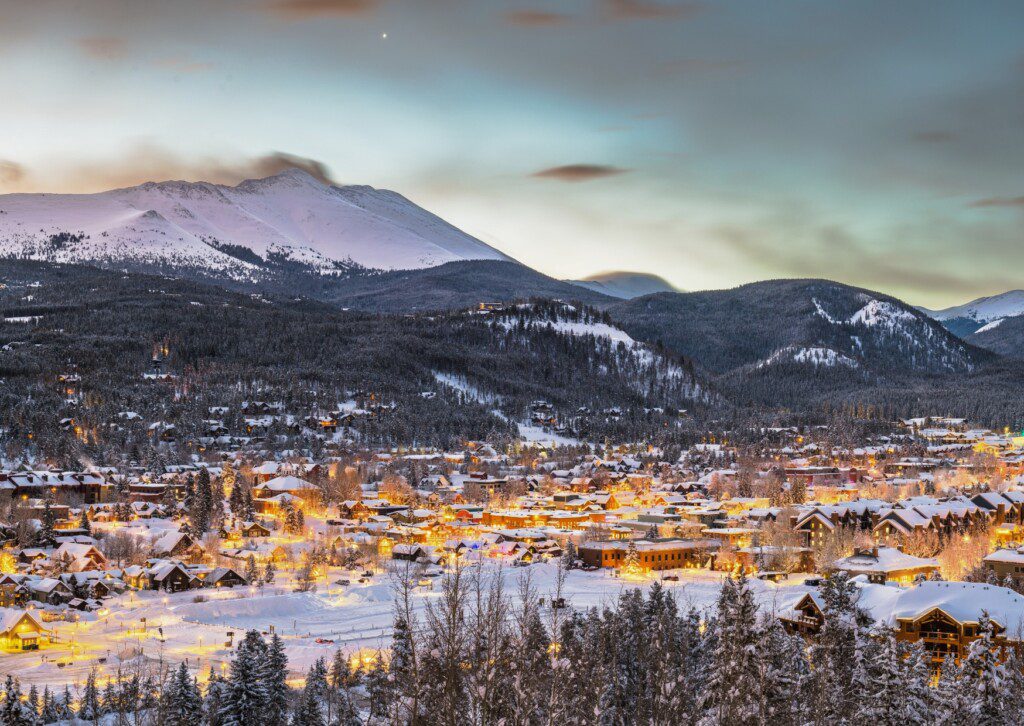 Snowy evening view of Silverthorne CO with mountain peaks, showcasing the scenic setting for a vacation rental Silverthorne CO.