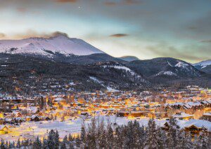 Snowy evening view of Silverthorne CO with mountain peaks, showcasing the scenic setting for a vacation rental Silverthorne CO.