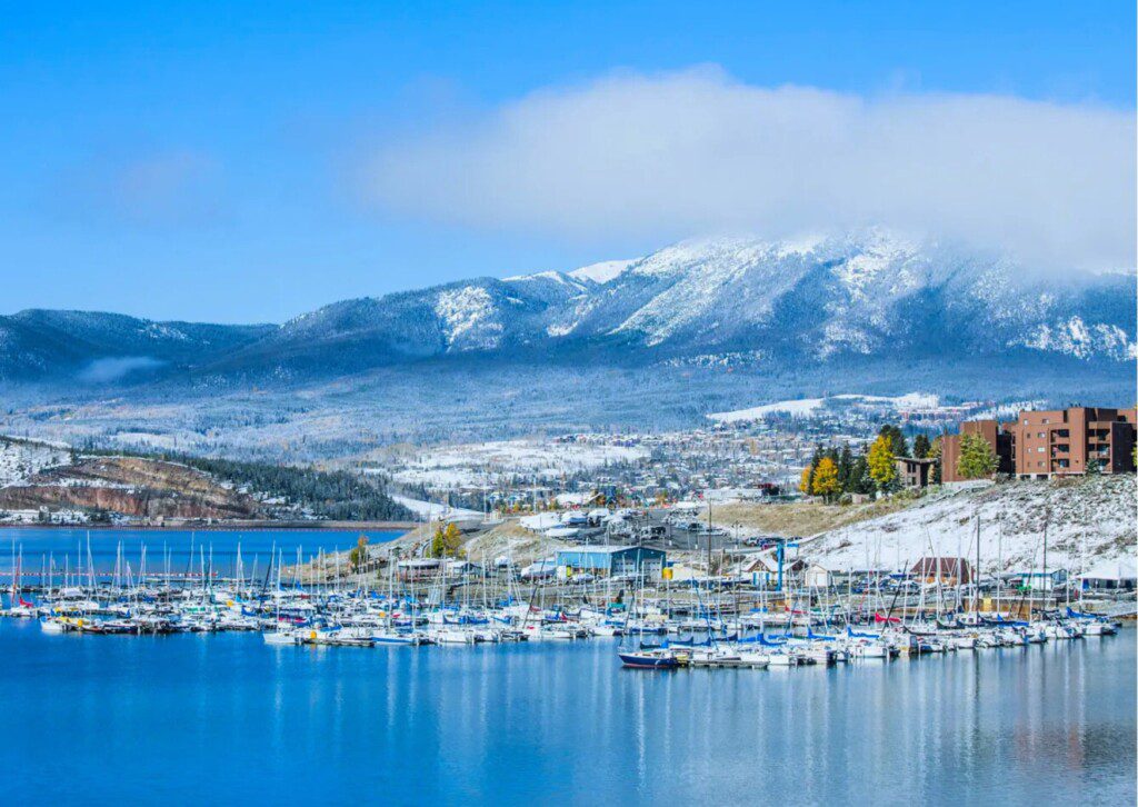 Boats lined up for Dillon Lake marina boat rentals on calm water with surrounding mountain scenery.
