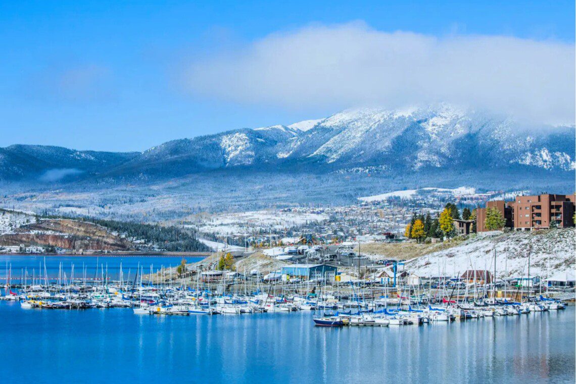 Boats lined up for Dillon Lake marina boat rentals on calm water with surrounding mountain scenery.