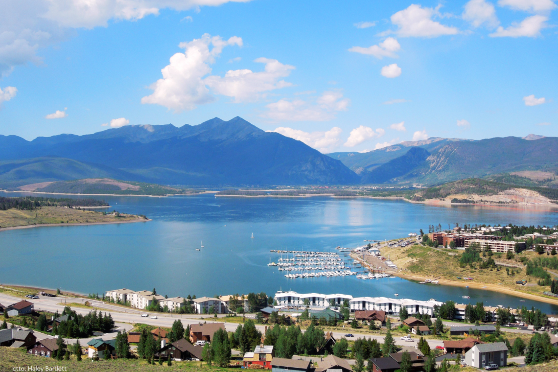 Lake Dillon boat rental with boats on the lake and the Rocky Mountains in the background on a clear summer day near Silverthorne, Colorado.