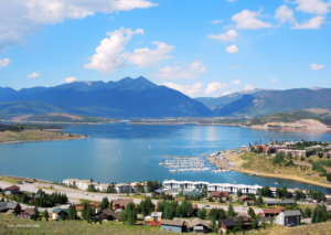 Lake Dillon boat rental with boats on the lake and the Rocky Mountains in the background on a clear summer day near Silverthorne, Colorado.